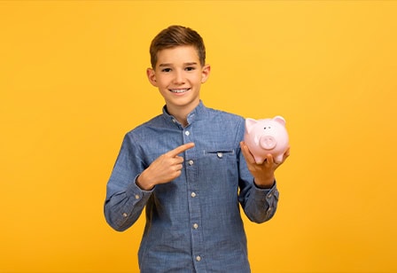 Teen boy pointing to piggy bank